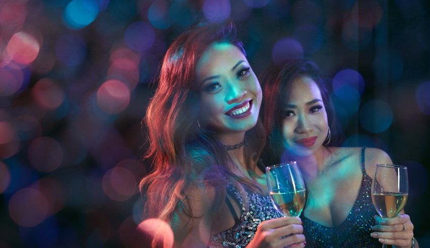 Two women holding champagne glasses at a party.