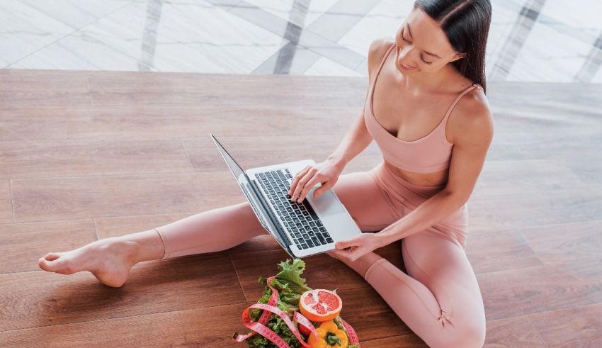 A woman sitting on the floor using a laptop.