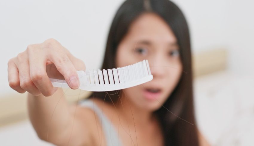 A woman is brushing her hair with a comb.