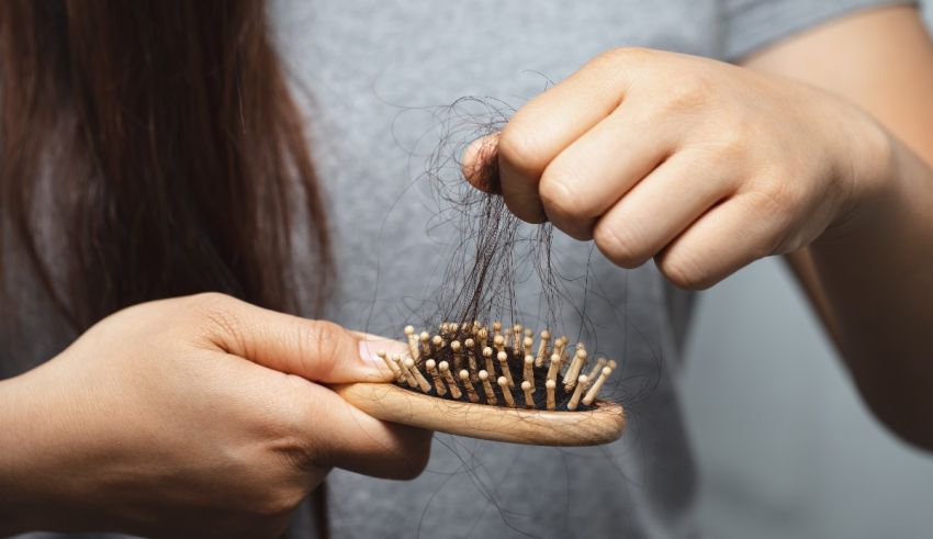 A woman is combing her hair with a wooden comb.