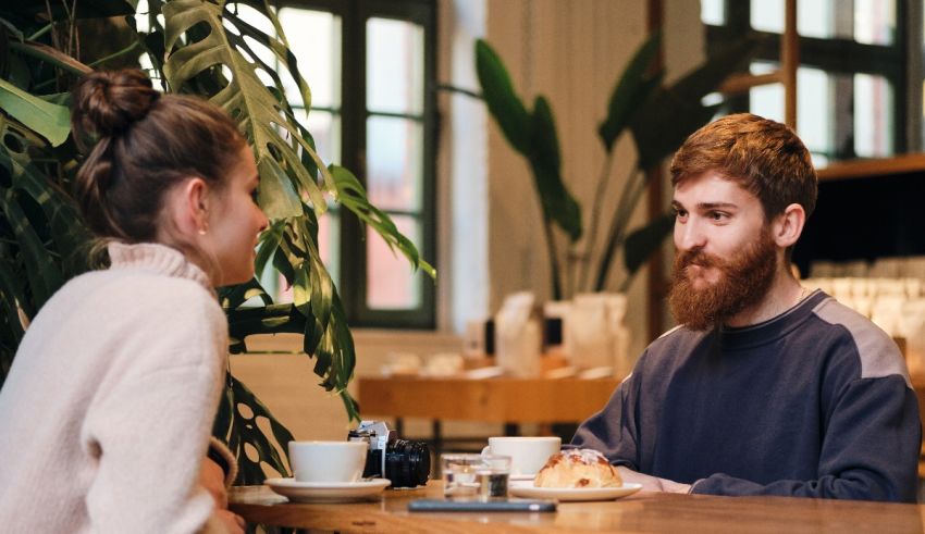 A man and woman sitting at a table in a coffee shop.
