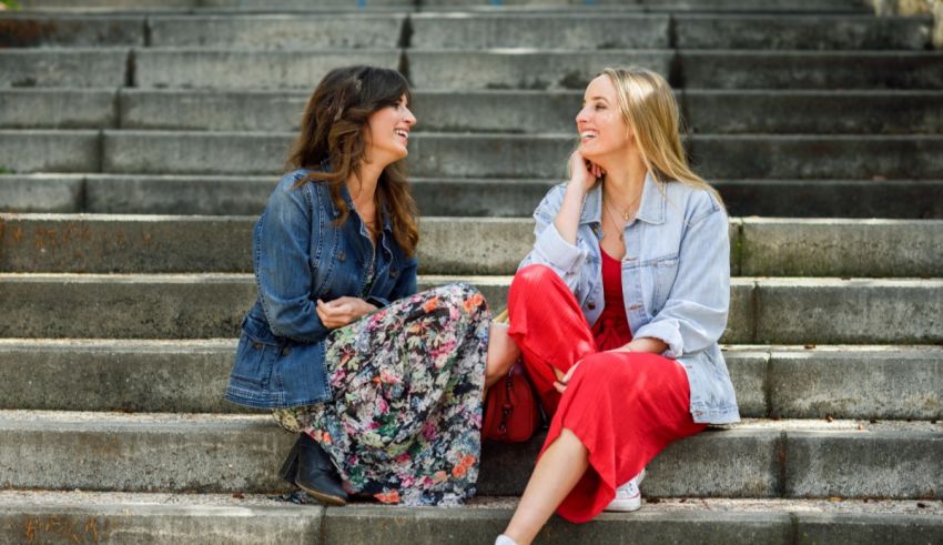 Two women sitting on steps talking to each other.