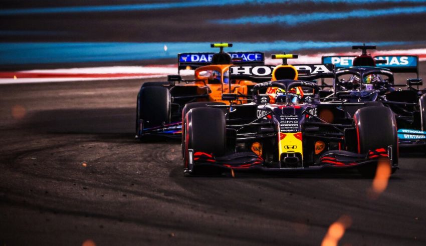 Two red bull racing cars racing on a track.