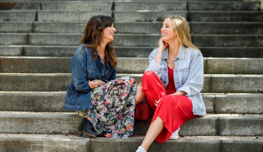 Two women sitting on steps talking to each other.