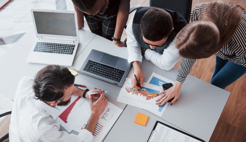 A group of people sitting around a table looking at graphs.