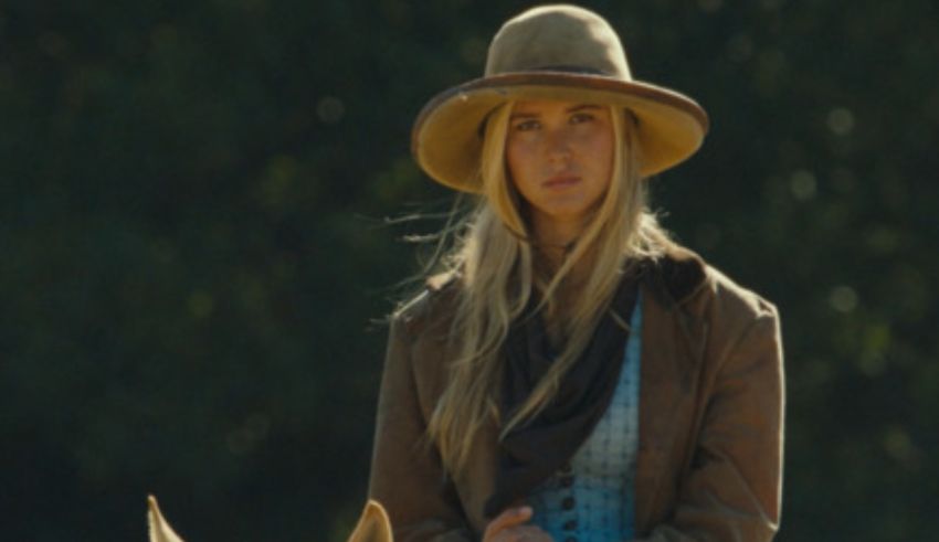 A woman in a cowboy hat riding a horse.