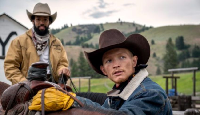 Two men in cowboy hats sitting on a horse.