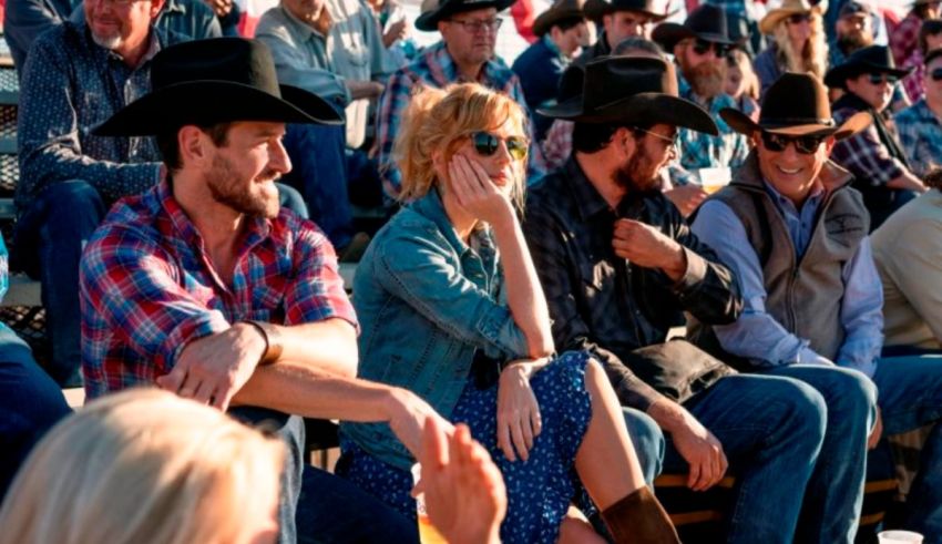 A group of people in cowboy hats sitting at a rodeo.