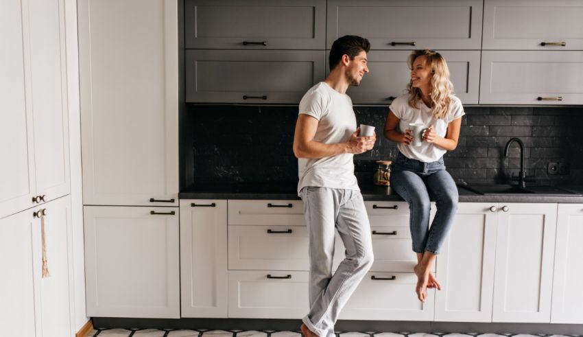 Young man and woman standing in the kitchen.