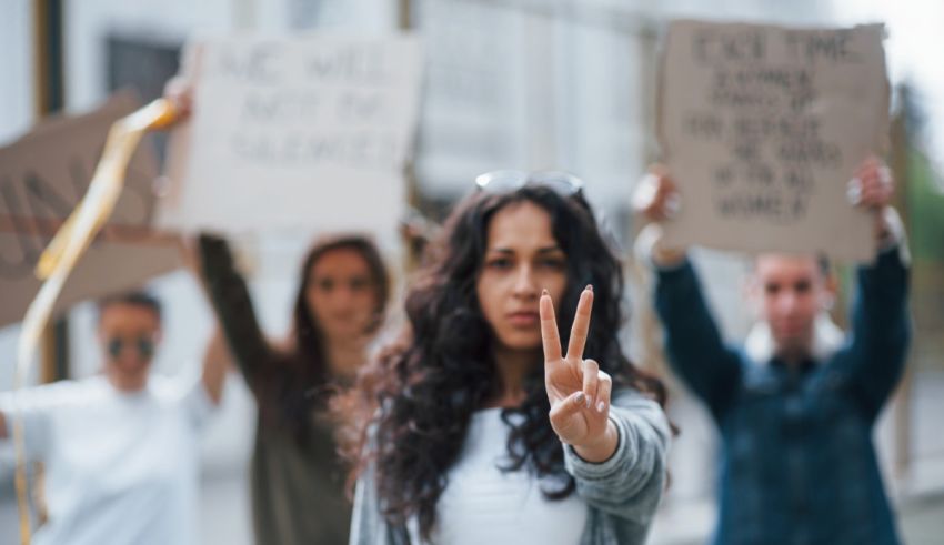 A group of people holding signs with the peace sign.