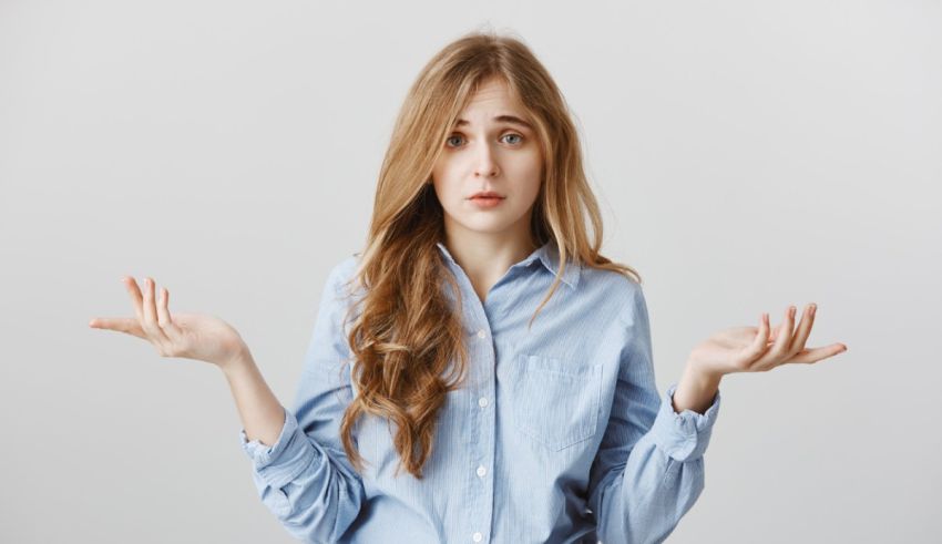 A young woman in a blue shirt with her hands outstretched.