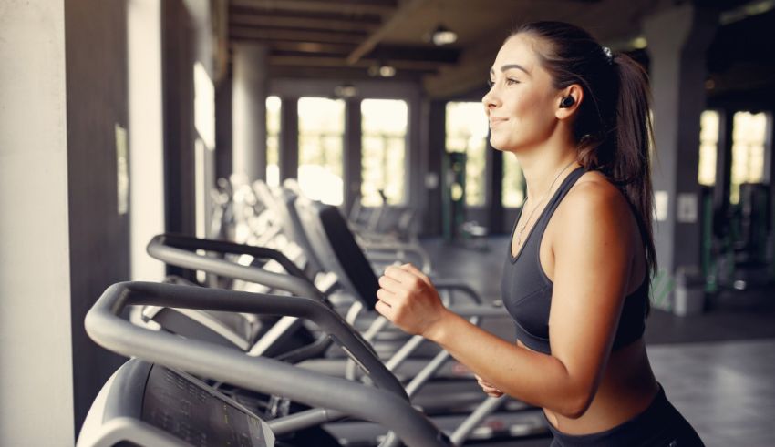 A woman running on a tread machine in a gym.