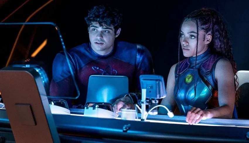 A man and woman sitting at a desk in front of a computer.