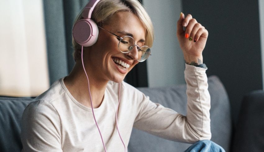 A woman is listening to music while sitting on a couch.