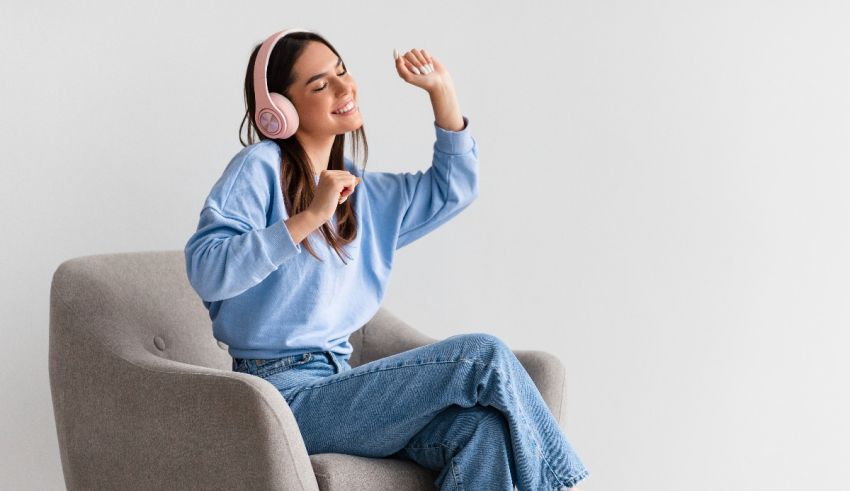 A young woman wearing headphones is sitting in a chair.