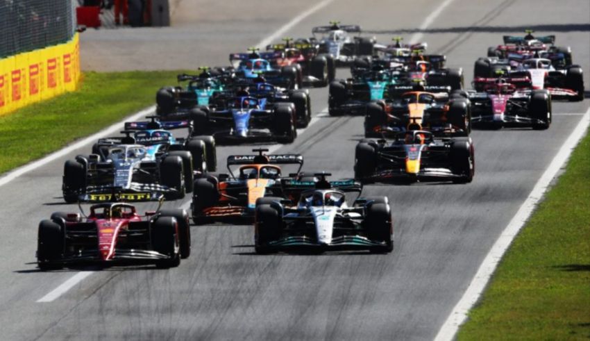 A group of racing cars going down a race track.