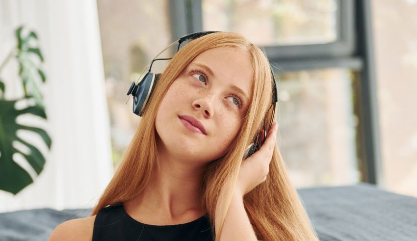 A young woman wearing headphones and listening to music.