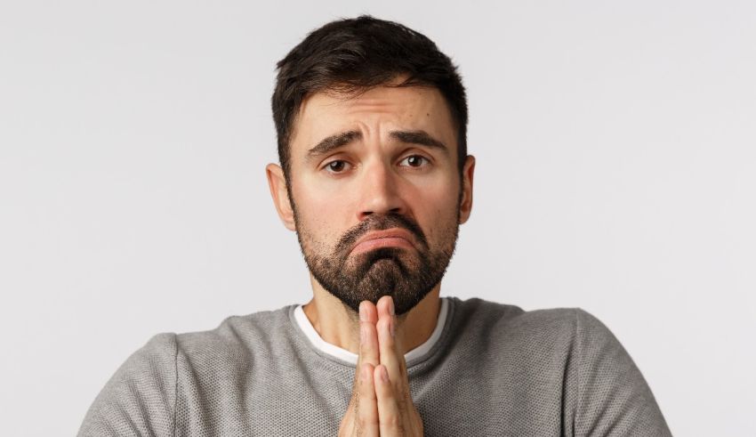 A man with a beard is praying with his hands.
