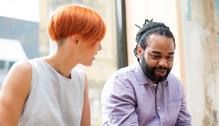 Two people sitting at a table talking to each other.