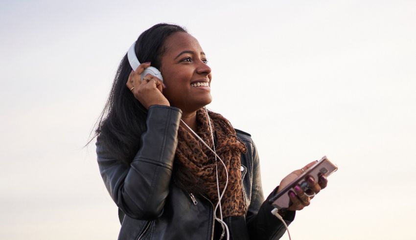 Young african american woman listening to music with headphones.