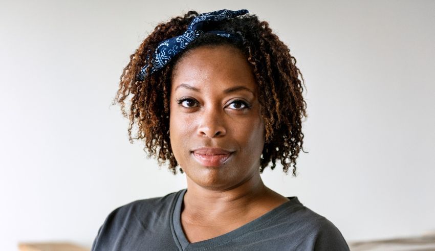 A black woman in a gray shirt with a bow on her head.