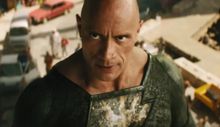 A bald man is standing in front of a city.