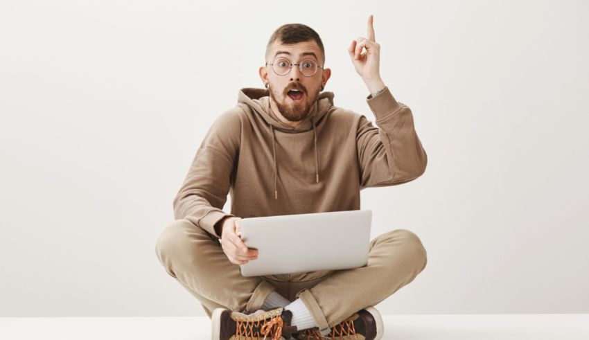 A man sitting on the floor with a laptop.