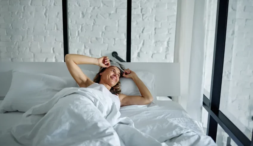 A woman is laying in bed with her head on her pillow.