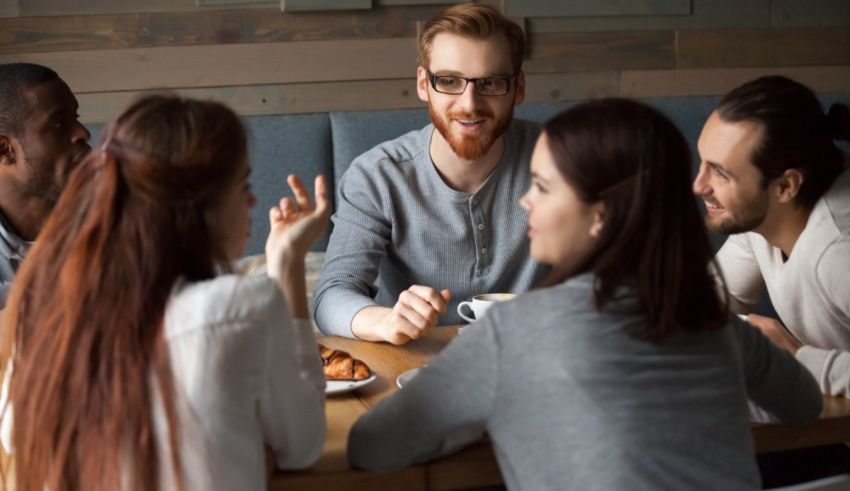 A group of people sitting around a table talking.