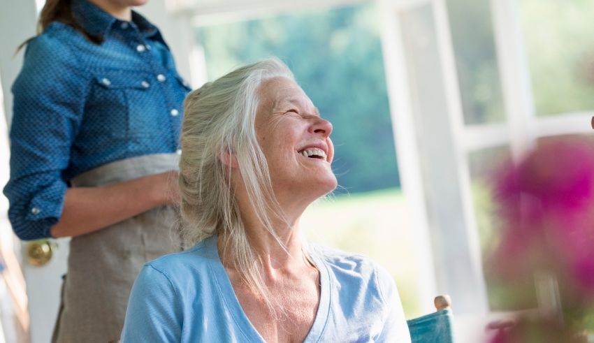 A woman is laughing while sitting at a table with another woman.