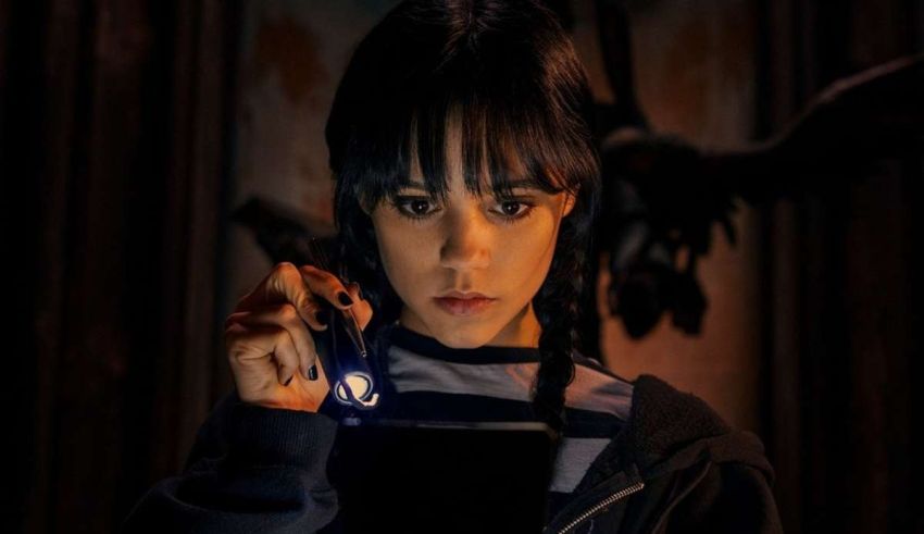 A girl holding a flashlight in front of a dark room.