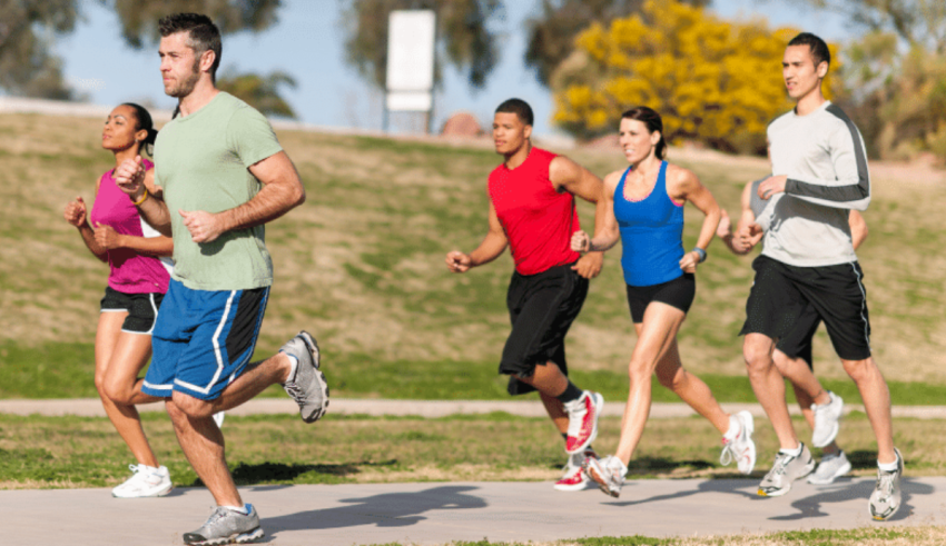 A group of people jogging in a park.