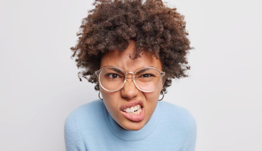 A black woman with glasses is making an angry face.