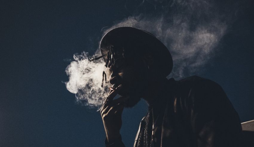 A man in a hat smoking a cigarette.