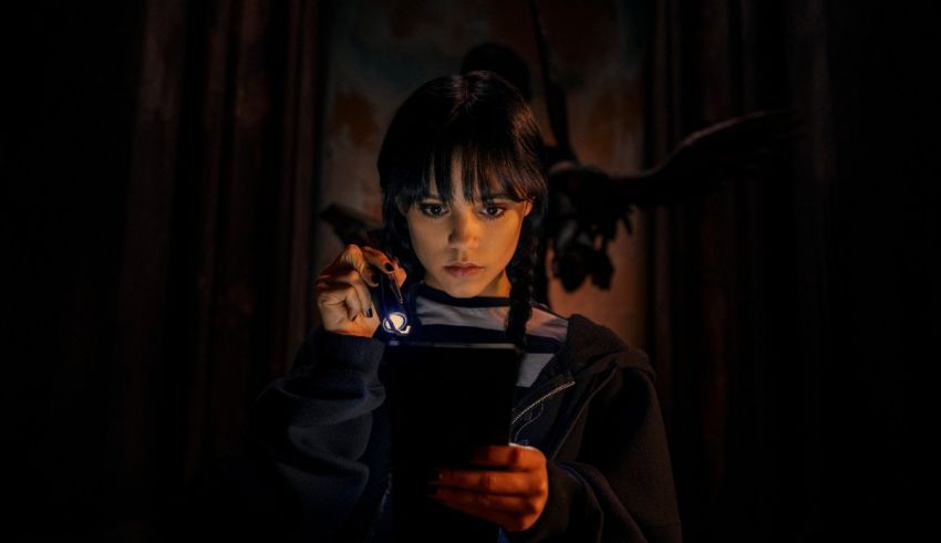 A girl holding a cell phone in the dark.