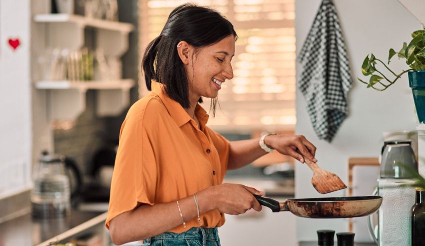 A woman is frying food in a frying pan.