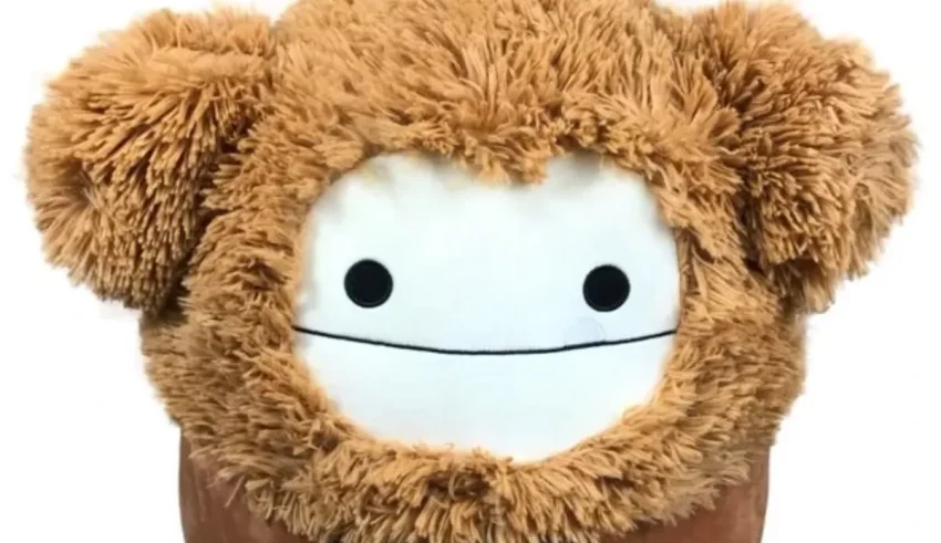 A brown stuffed animal is sitting on a white background.