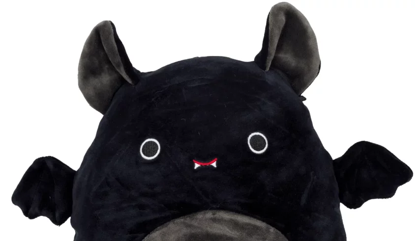 A black plush bat sitting on a white background.
