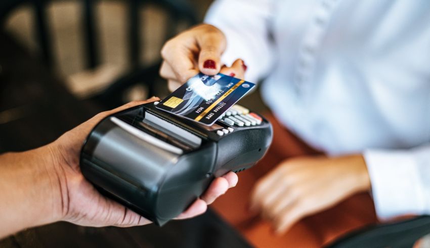 A person is handing a credit card to another person.