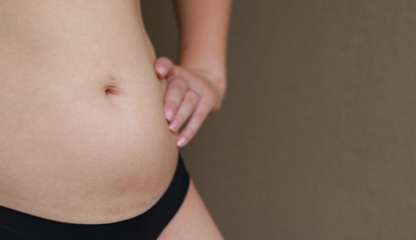 A woman in a black bikini showing her stomach.