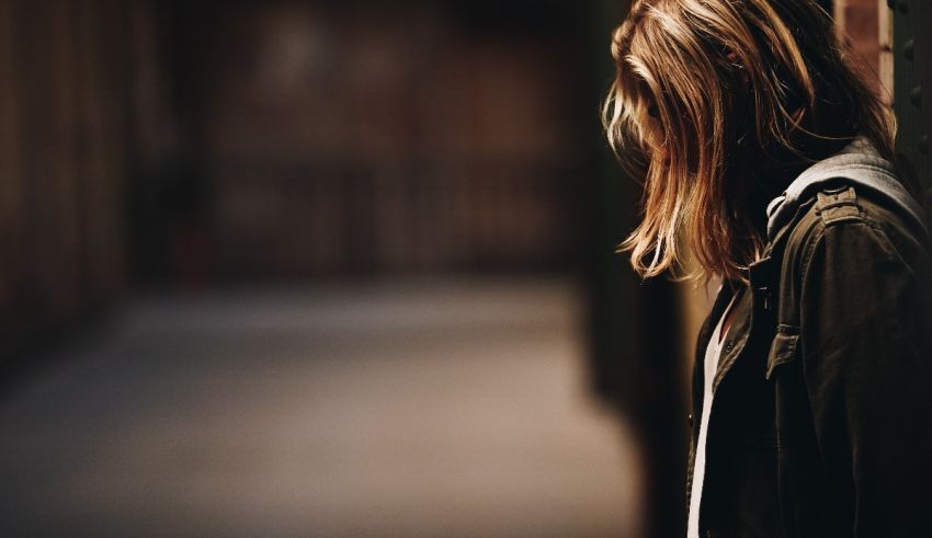 A woman with long hair is leaning against a wall.