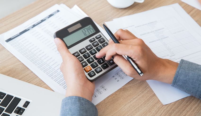 A person using a calculator on a desk.