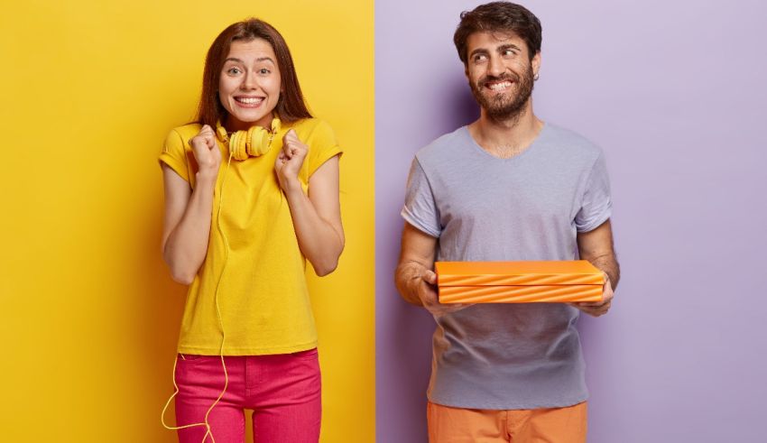 A young man and woman holding a box on a colorful background.