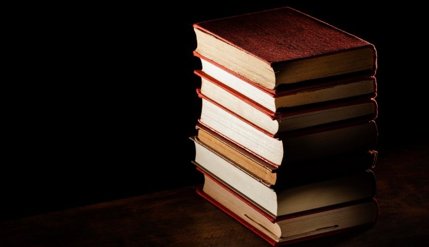 A stack of books on a dark table.