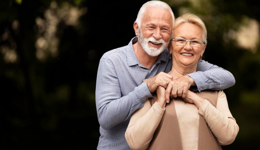 An older couple hugging each other in the park.