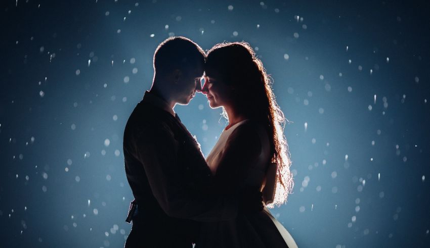 A silhouette of a couple embracing in the snow.