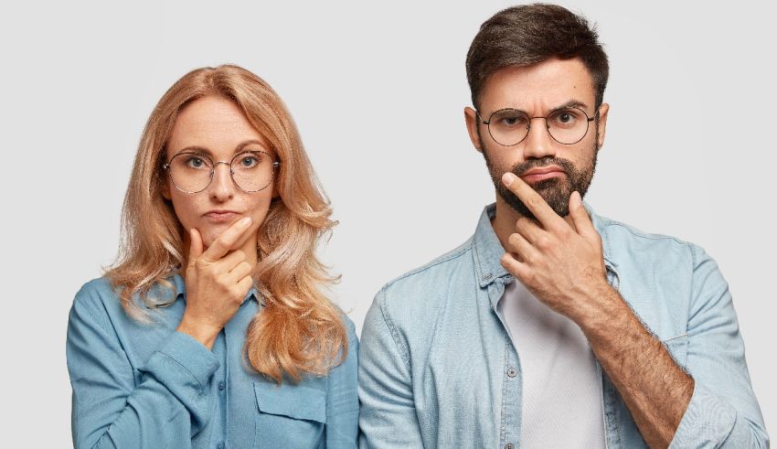 A man and a woman looking at each other with their finger on their lips.