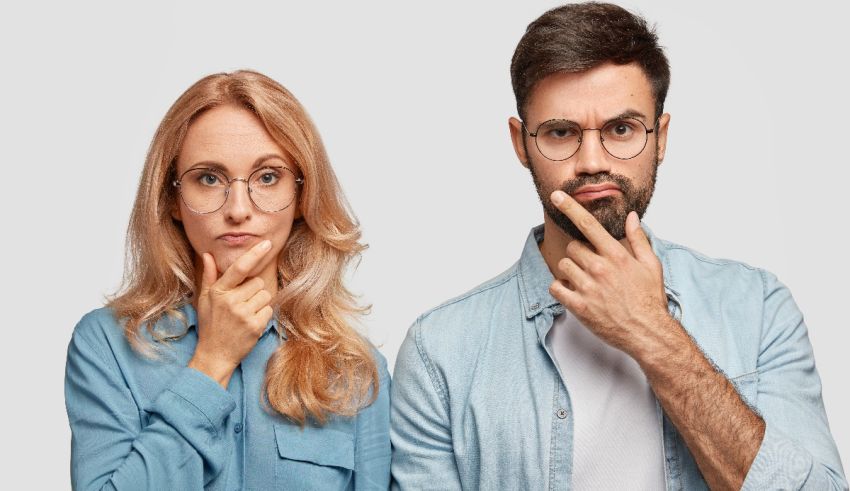 A man and a woman with glasses are looking at each other.