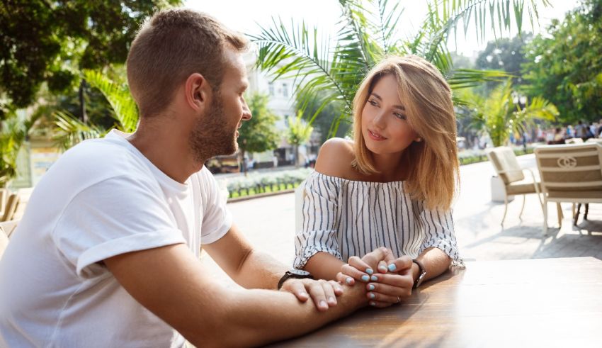 A man and woman sitting at an outdoor table.