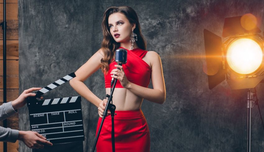 A woman in a red dress is holding a microphone.